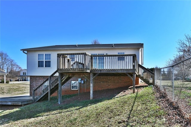 rear view of house with a wooden deck, a yard, stairs, and fence