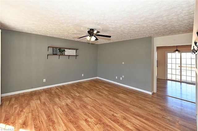 unfurnished room featuring light wood finished floors, baseboards, a textured ceiling, and ceiling fan