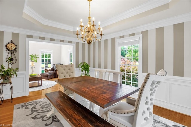 6707 Fegan Rd, Summerfield, NC 27358 - dining area with a chandelier, a wainscoted wall, crown molding, light wood-type flooring, and a tray ceiling