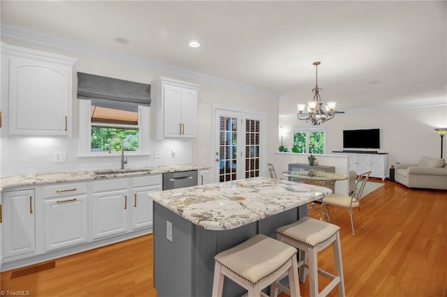 6707 Fegan Rd, Summerfield, NC 27358 - kitchen with dishwasher, a kitchen bar, white cabinetry, plenty of natural light, and ornamental molding