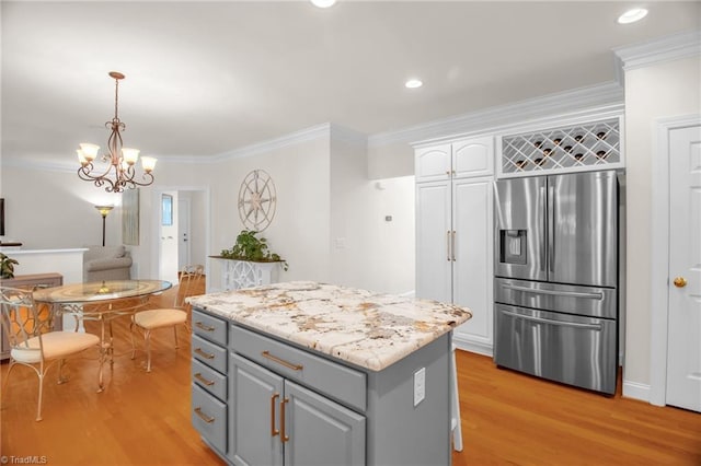 6707 Fegan Rd, Summerfield, NC 27358 - kitchen with stainless steel fridge, gray cabinetry, light wood-type flooring, a center island, and white cabinetry