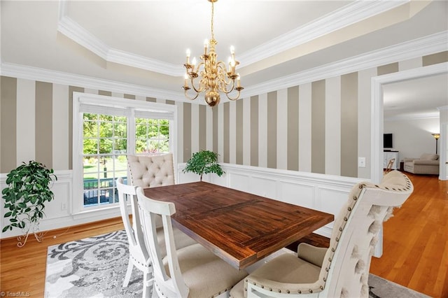 6707 Fegan Rd, Summerfield, NC 27358 - dining room featuring crown molding, a chandelier, light wood finished floors, a wainscoted wall, and a decorative wall