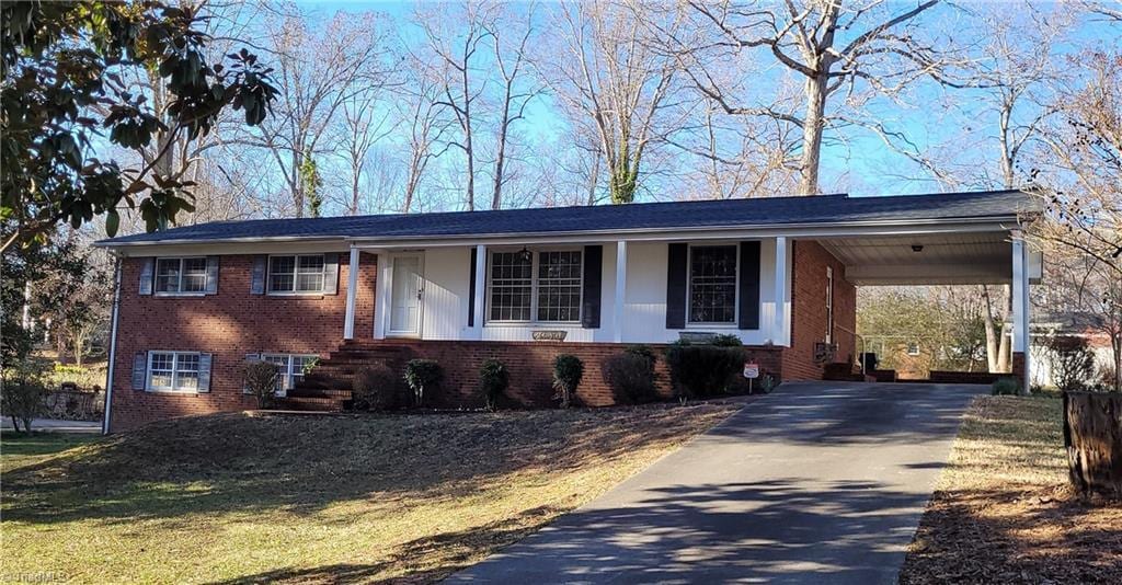 view of front of property featuring a carport, concrete driveway, and brick siding