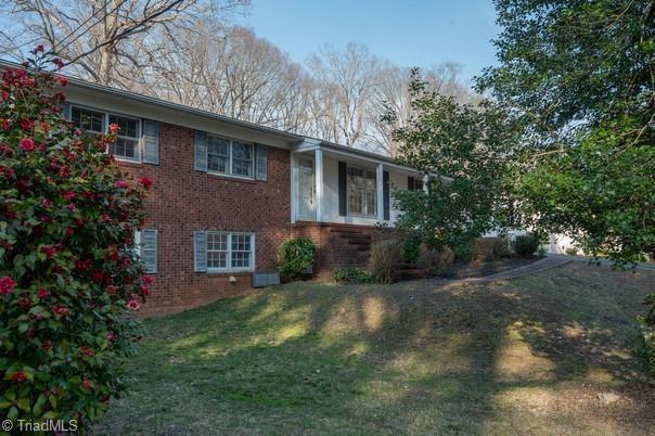 view of side of home featuring brick siding and a lawn