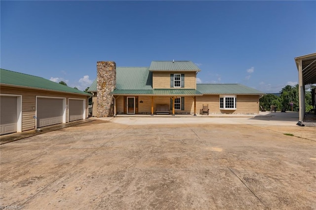 rear view of house featuring a garage and an outdoor structure