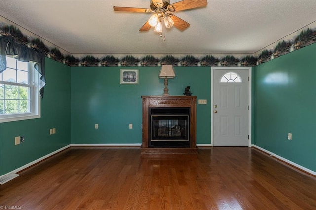 unfurnished living room with a textured ceiling, wood-type flooring, and ceiling fan