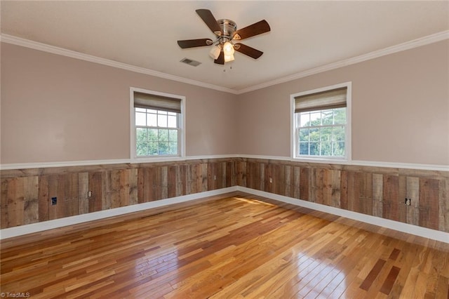 unfurnished room featuring a healthy amount of sunlight, light hardwood / wood-style floors, crown molding, and ceiling fan