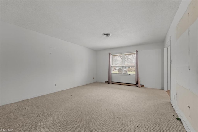 unfurnished room featuring light colored carpet and a textured ceiling