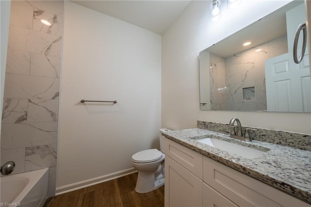 full bathroom with vanity, hardwood / wood-style flooring, toilet, and tiled shower / bath