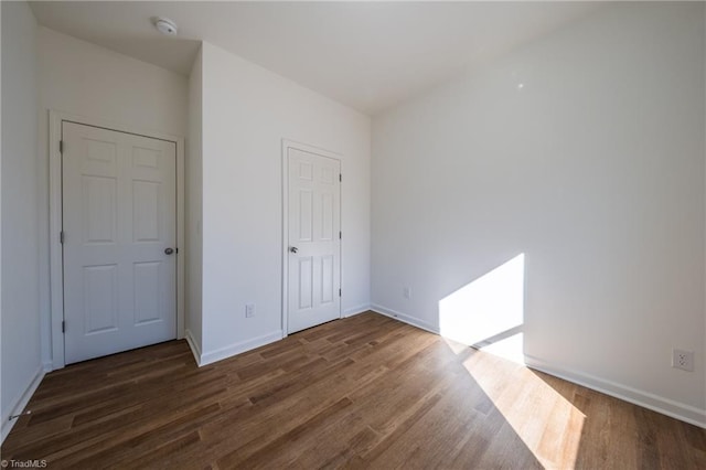 unfurnished bedroom with a closet and dark wood-type flooring