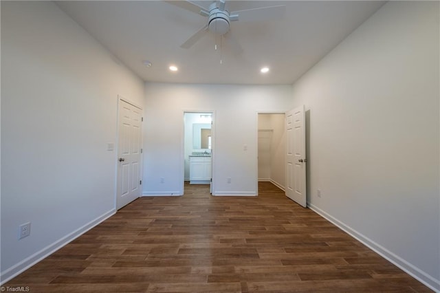 unfurnished bedroom featuring ensuite bathroom, ceiling fan, dark hardwood / wood-style floors, and a closet