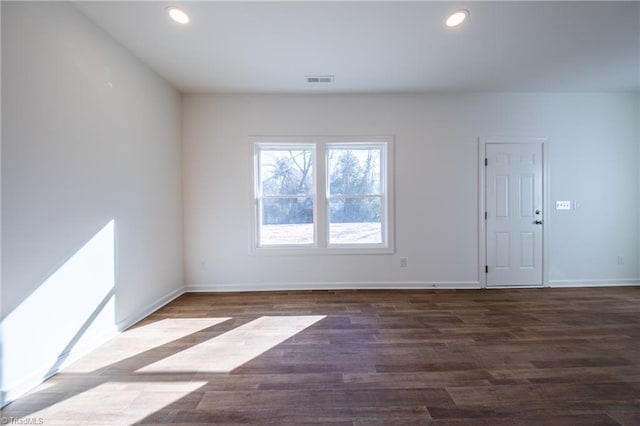 unfurnished room with dark wood-type flooring