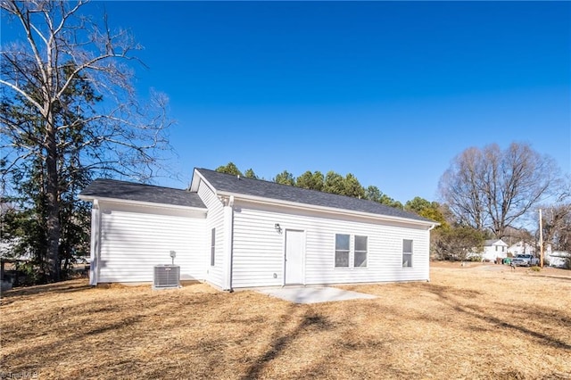 back of property with a lawn, central air condition unit, and a patio