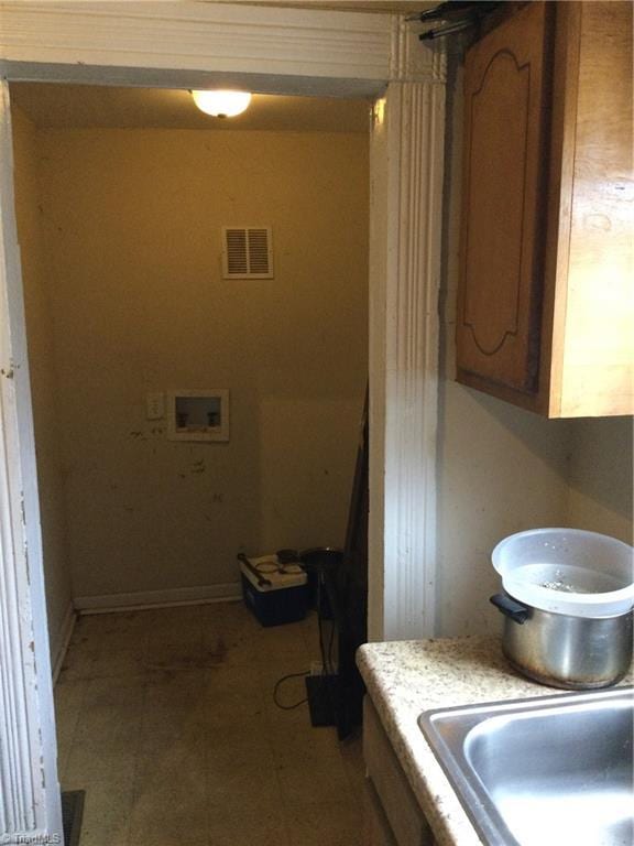 washroom featuring visible vents, washer hookup, a sink, baseboards, and laundry area