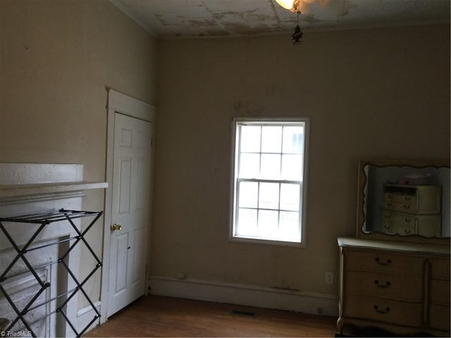 unfurnished bedroom with wood finished floors and visible vents