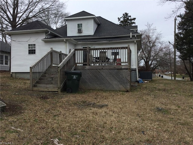 rear view of property with a lawn, a wooden deck, and a shingled roof