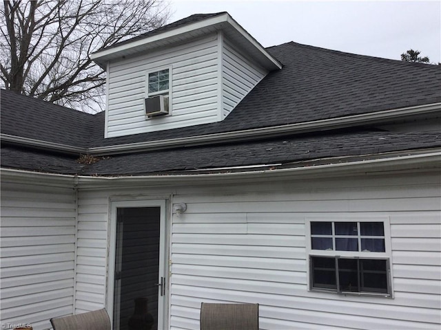 exterior space featuring cooling unit and a shingled roof