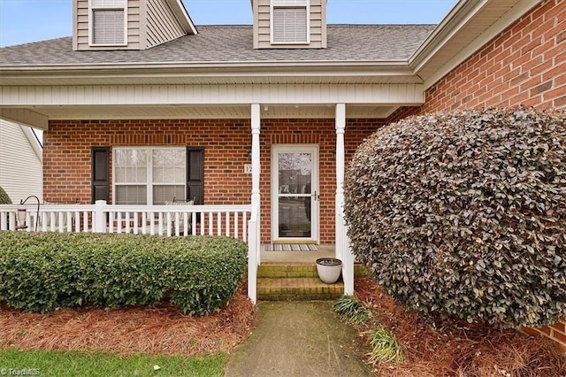 view of exterior entry featuring covered porch