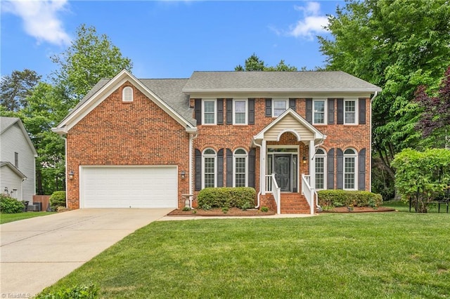 4 Beech Grove Ct, Greensboro, NC 27455 - colonial house featuring brick siding, concrete driveway, and a front lawn