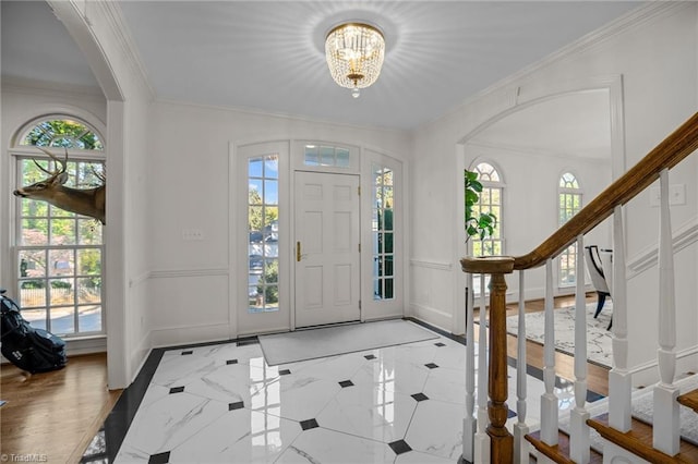 entrance foyer with a decorative wall, a healthy amount of sunlight, and a notable chandelier