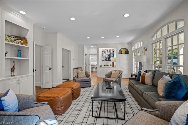 living area with ornamental molding, recessed lighting, light wood-style flooring, and built in features