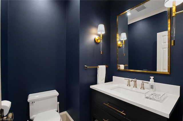 bathroom with visible vents, toilet, vanity, and baseboards