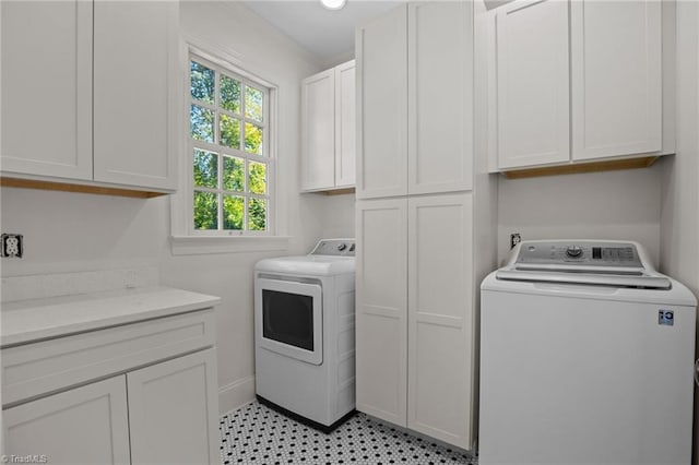 laundry room with washer and clothes dryer, cabinet space, and baseboards