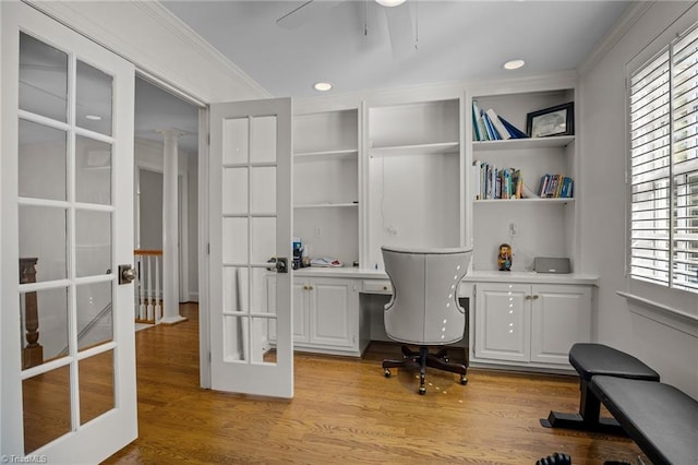 office area with ornamental molding, light wood-style floors, french doors, and built in study area