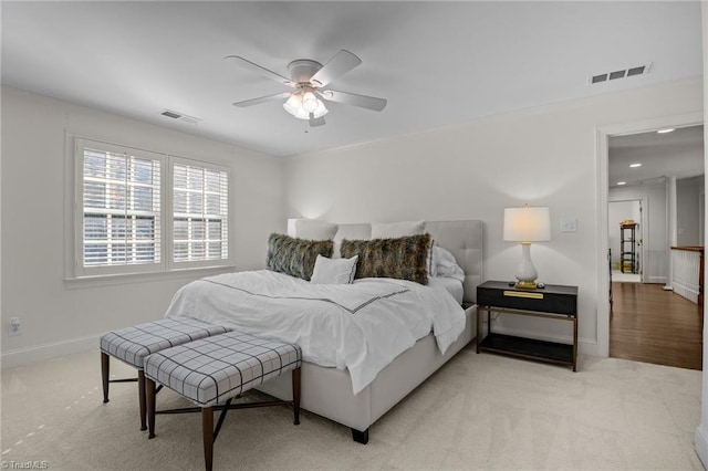 bedroom featuring light colored carpet, visible vents, ceiling fan, and baseboards