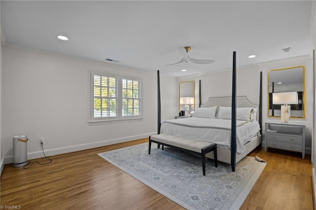 bedroom with recessed lighting, wood finished floors, baseboards, visible vents, and crown molding