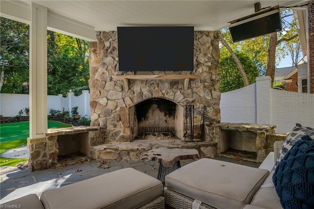 view of patio featuring an outdoor stone fireplace and fence