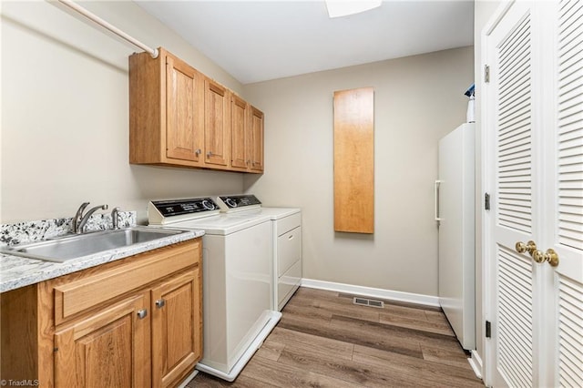1312 Gilbrook Ct, High Point, NC 27262 - laundry room with washer and dryer, wood finished floors, cabinet space, and baseboards
