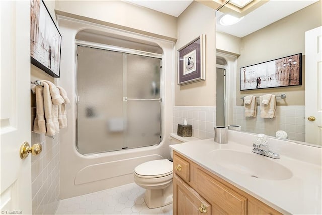 1312 Gilbrook Ct, High Point, NC 27262 - bathroom featuring vanity, toilet, tile patterned flooring, combined bath / shower with glass door, and tile walls