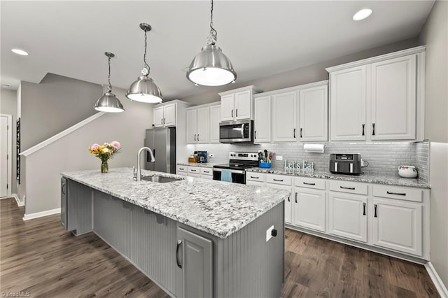 kitchen featuring stainless steel appliances, a sink, white cabinets, and recessed lighting