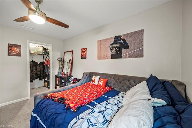 carpeted bedroom featuring a spacious closet, ceiling fan, a closet, and baseboards
