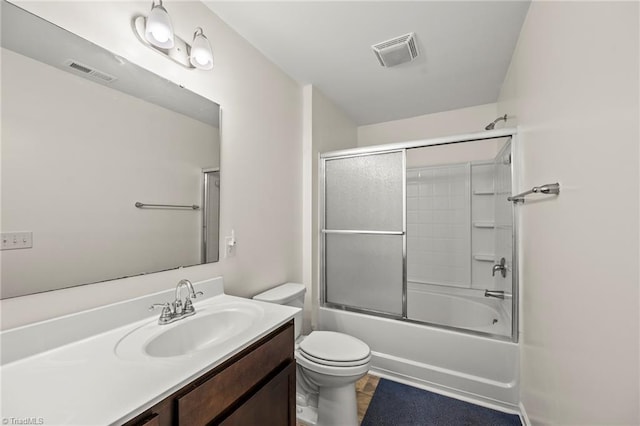 full bath featuring toilet, vanity, and combined bath / shower with glass door