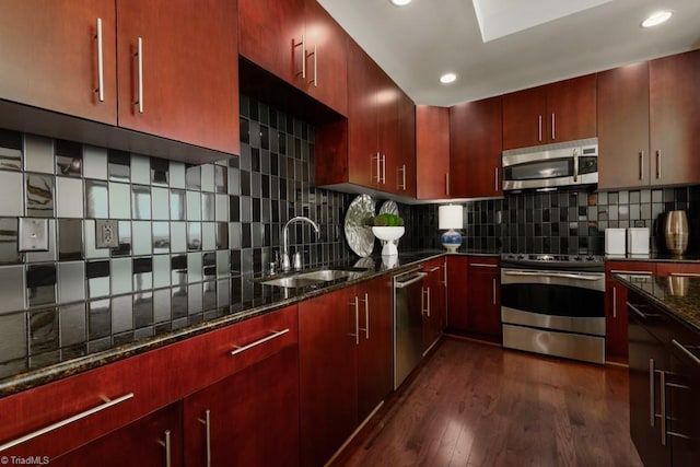 kitchen with a sink, dark wood-type flooring, reddish brown cabinets, and stainless steel appliances