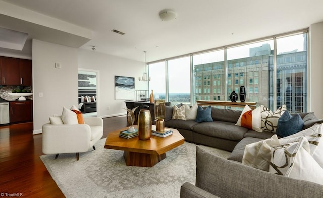 living area featuring a wealth of natural light, a wall of windows, dark wood-type flooring, and baseboards