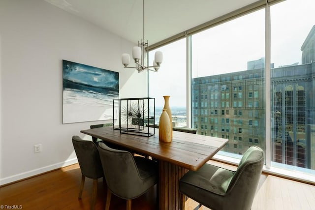 dining space featuring a notable chandelier, wood finished floors, plenty of natural light, and baseboards