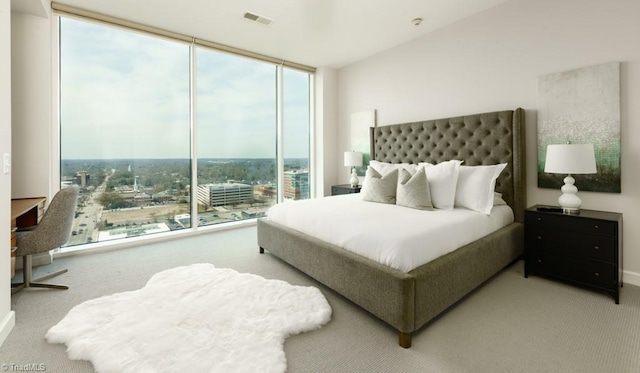 bedroom with visible vents, carpet flooring, and a wall of windows