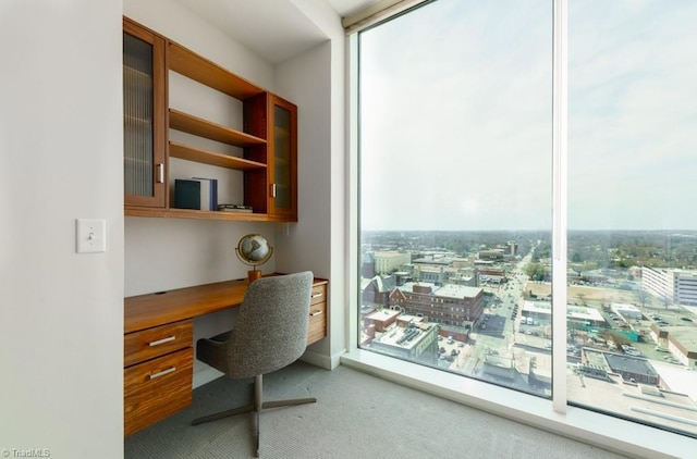 office area with a wall of windows, carpet floors, and built in study area