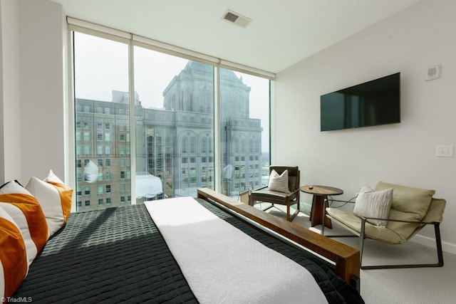 carpeted bedroom featuring visible vents, baseboards, and expansive windows