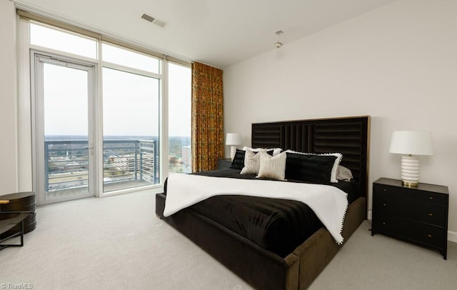 carpeted bedroom with visible vents and a wall of windows