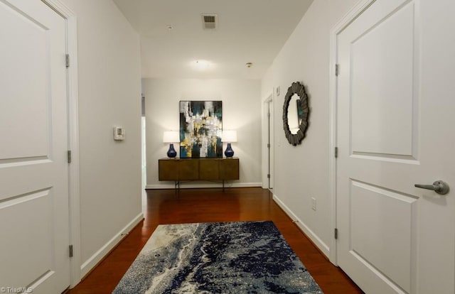 corridor with visible vents, baseboards, and wood finished floors