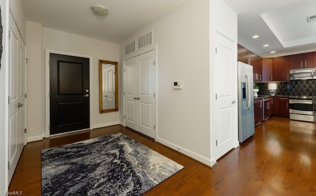 foyer entrance featuring dark wood-type flooring, recessed lighting, baseboards, and visible vents