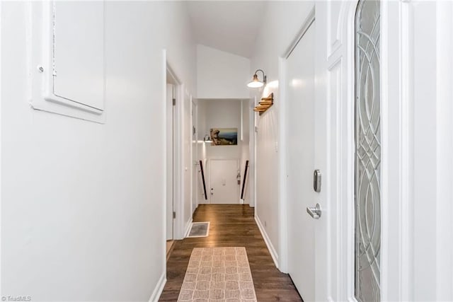 hallway featuring lofted ceiling and dark hardwood / wood-style floors