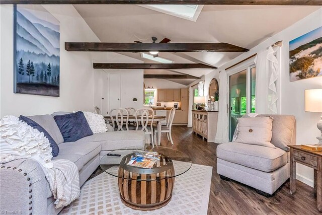 dining area featuring vaulted ceiling with skylight and dark hardwood / wood-style flooring