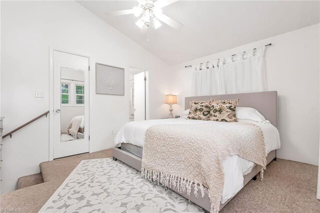 carpeted bedroom featuring high vaulted ceiling, ceiling fan, and ensuite bathroom