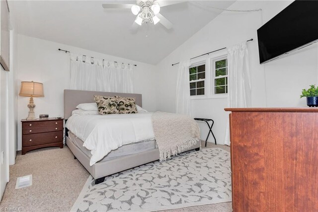 carpeted bedroom with multiple windows, vaulted ceiling, and ceiling fan