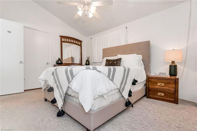 bedroom featuring lofted ceiling, ceiling fan, light colored carpet, and connected bathroom